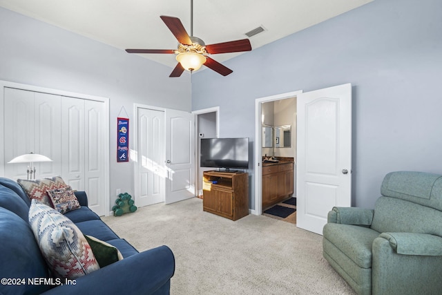 living room featuring ceiling fan, high vaulted ceiling, and light colored carpet