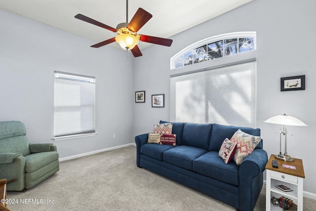 living room with ceiling fan, a towering ceiling, and carpet floors