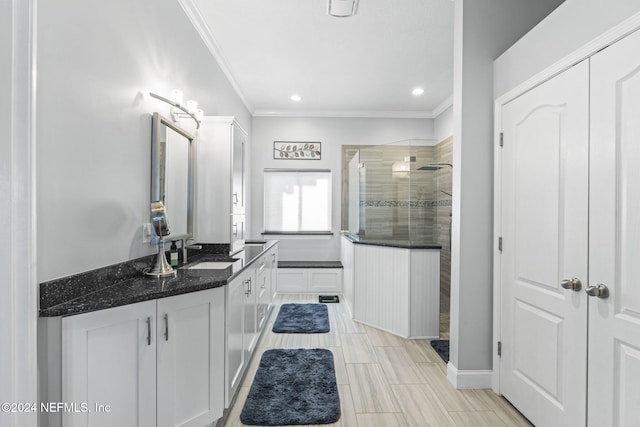 bathroom featuring vanity, ornamental molding, and tiled shower