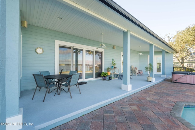 view of patio with ceiling fan and a hot tub