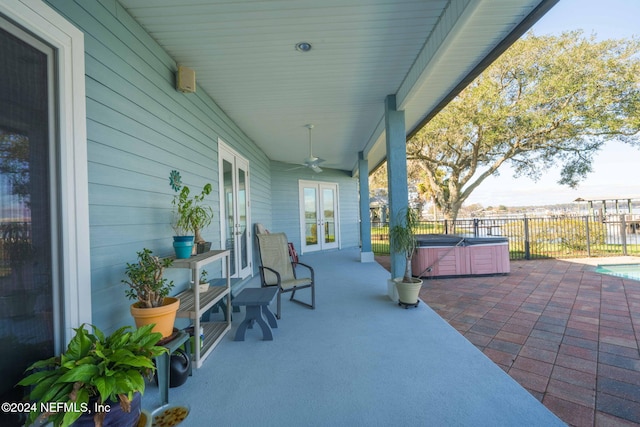 view of patio featuring french doors, a hot tub, and ceiling fan