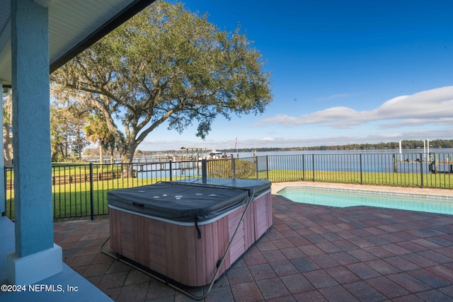 view of patio / terrace with a swimming pool with hot tub and a water view