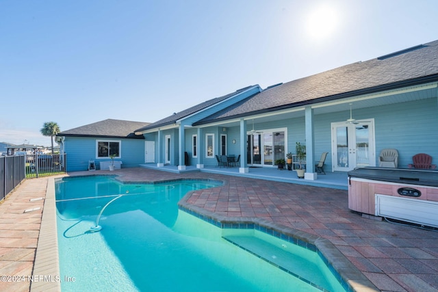 view of swimming pool with french doors, a hot tub, and a patio area