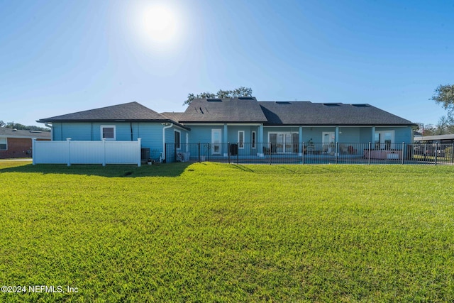 rear view of house featuring a yard