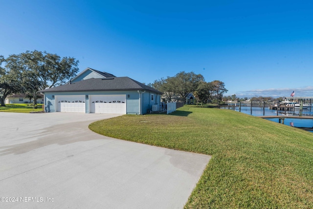 exterior space featuring a front lawn, a water view, and a garage