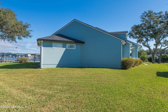 view of side of home with a yard