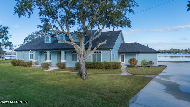 cape cod home with a water view, covered porch, and a front yard