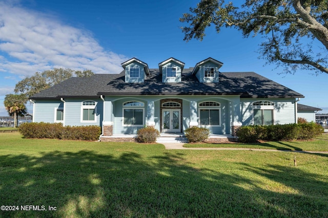 cape cod-style house featuring covered porch and a front yard