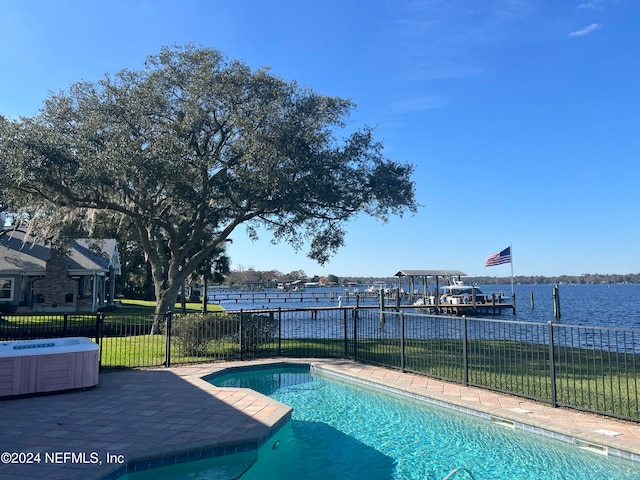 view of pool with a yard, a patio area, a dock, and a water view