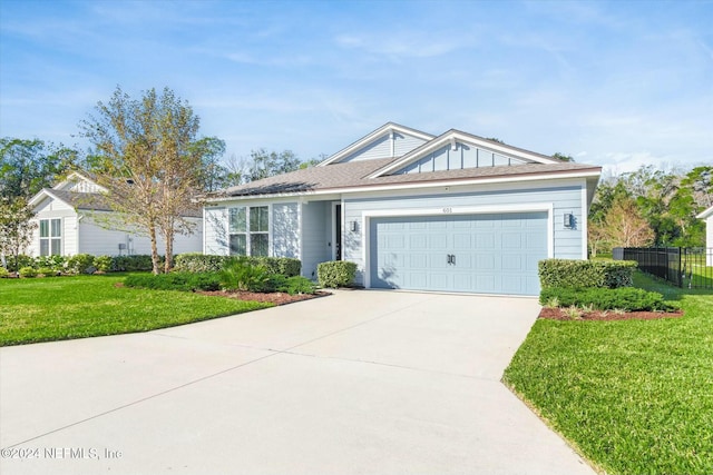 single story home featuring a garage and a front lawn