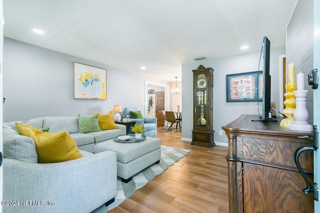 living room featuring a chandelier and light hardwood / wood-style flooring