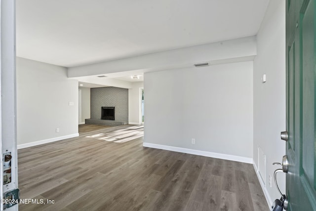 unfurnished living room featuring dark hardwood / wood-style flooring and a fireplace