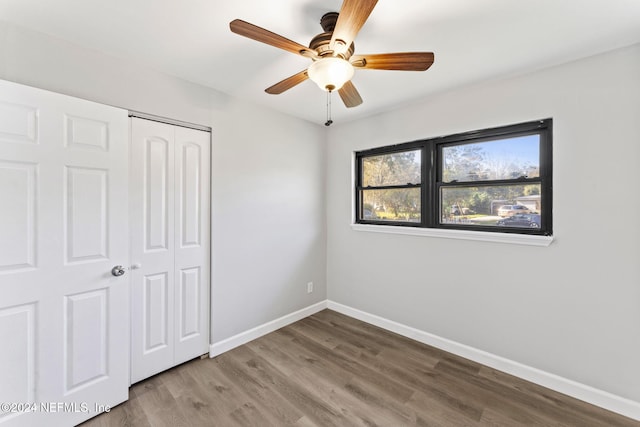 unfurnished bedroom featuring ceiling fan, wood-type flooring, and a closet