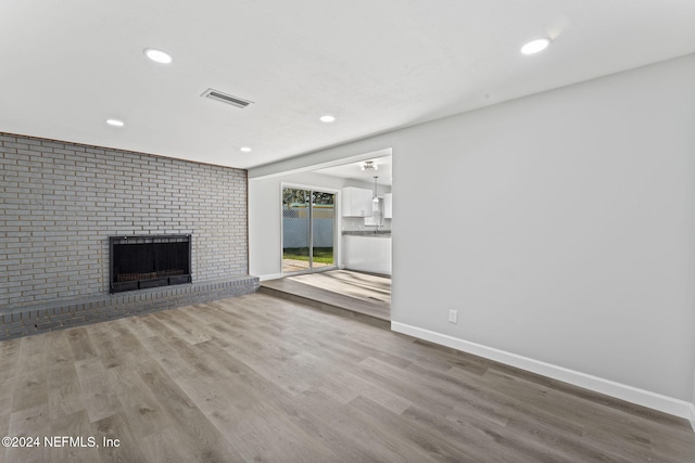 unfurnished living room with a fireplace and wood-type flooring