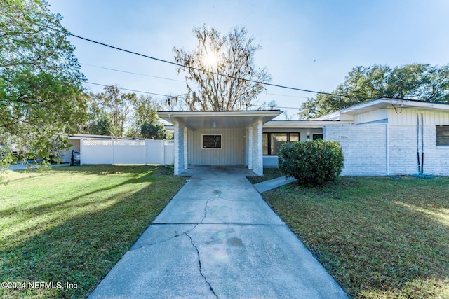 view of front of house with a carport and a front lawn