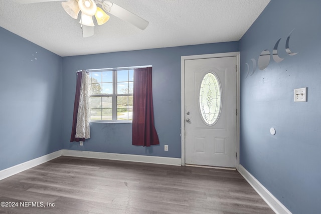 foyer entrance featuring hardwood / wood-style floors, ceiling fan, a healthy amount of sunlight, and a textured ceiling