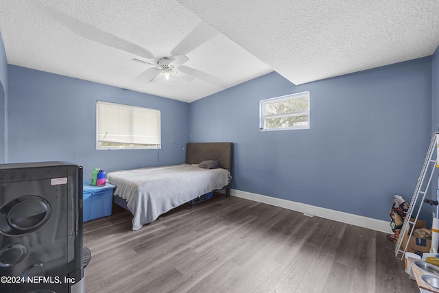 bedroom with ceiling fan, hardwood / wood-style floors, and a textured ceiling