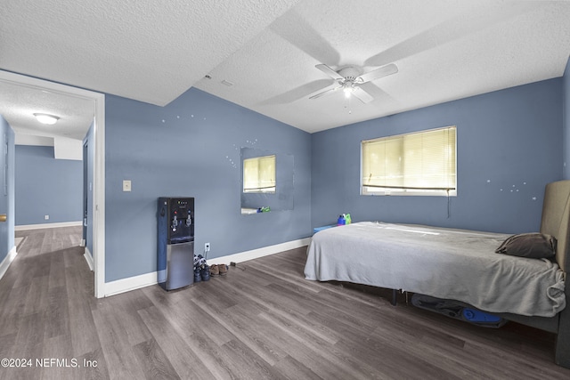 bedroom with lofted ceiling, ceiling fan, wood-type flooring, and a textured ceiling