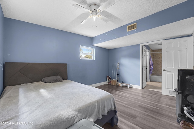 bedroom featuring hardwood / wood-style flooring, ceiling fan, ensuite bathroom, and a textured ceiling