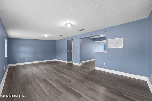 unfurnished room with a textured ceiling and dark wood-type flooring