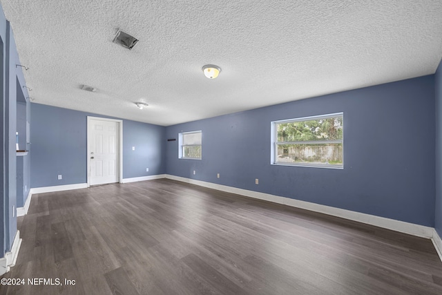 unfurnished room featuring dark hardwood / wood-style floors and a textured ceiling