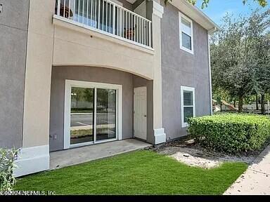 entrance to property with a lawn and a balcony