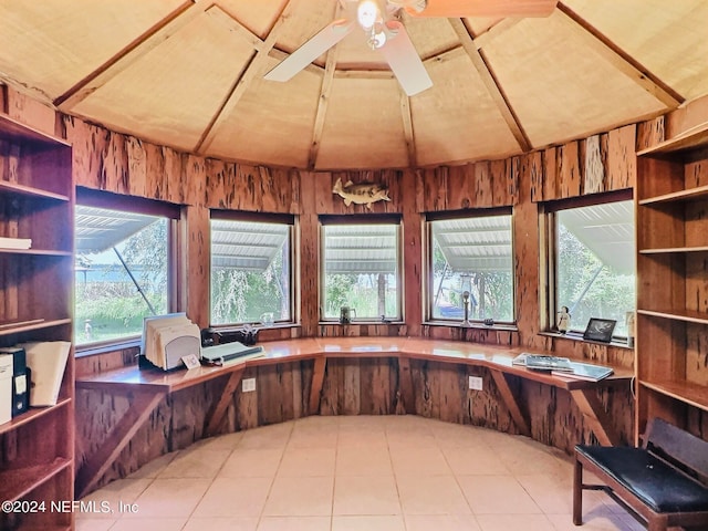 unfurnished office featuring wood walls, ceiling fan, and lofted ceiling