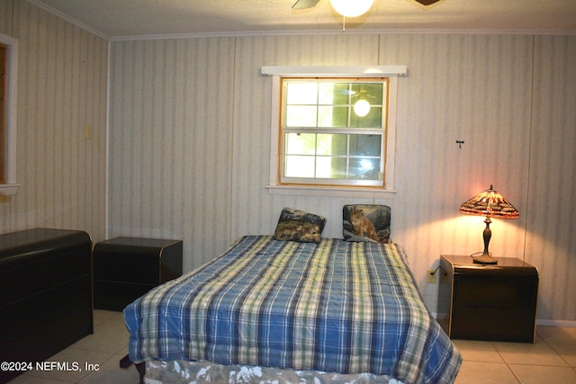 tiled bedroom featuring ceiling fan and crown molding