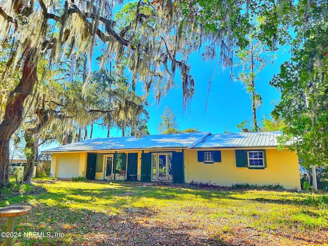 single story home featuring a garage and a front lawn