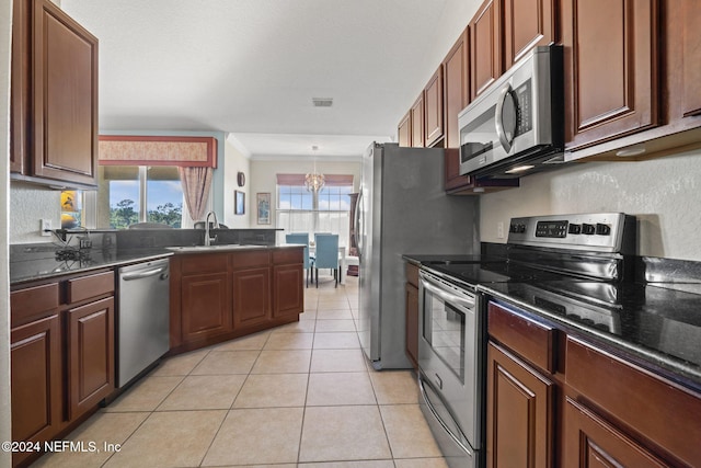 kitchen with light tile patterned floors, stainless steel appliances, plenty of natural light, and sink