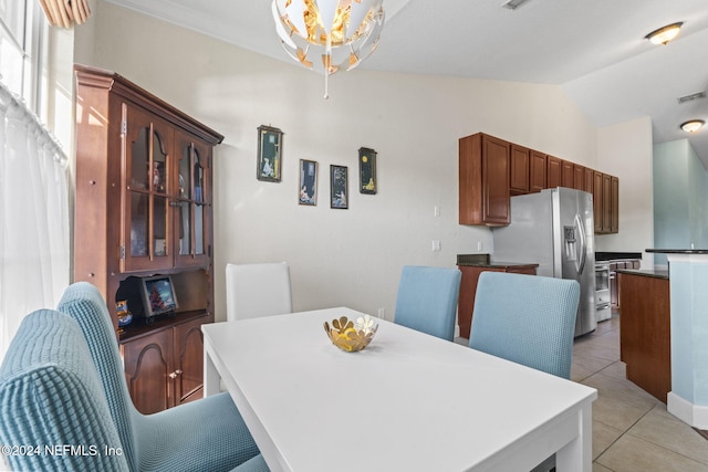 dining space with light tile patterned floors and lofted ceiling