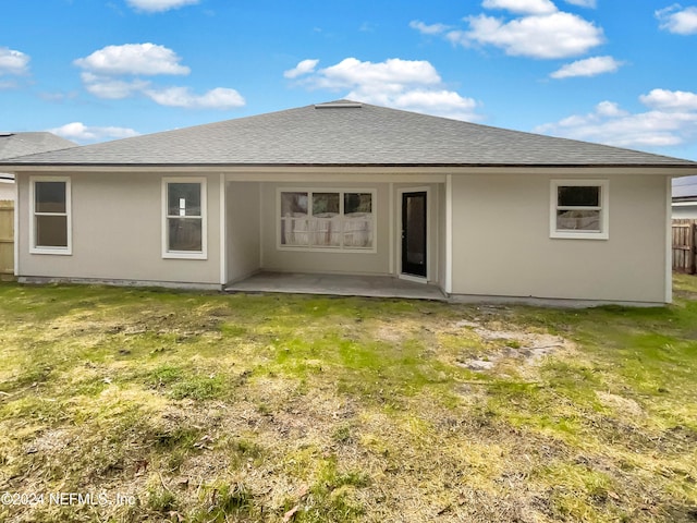 back of house featuring a lawn and a patio