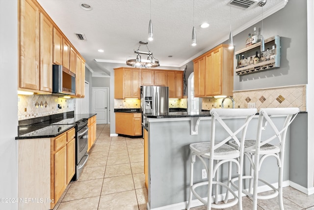 kitchen featuring a kitchen bar, ornamental molding, a textured ceiling, and appliances with stainless steel finishes