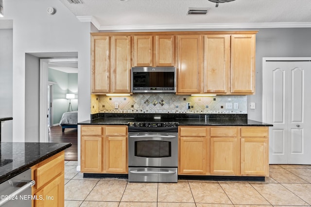 kitchen featuring dark stone counters, decorative backsplash, light tile patterned floors, ornamental molding, and stainless steel appliances