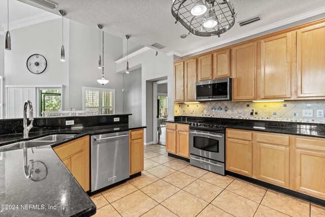 kitchen featuring sink, hanging light fixtures, stainless steel appliances, a textured ceiling, and light tile patterned floors