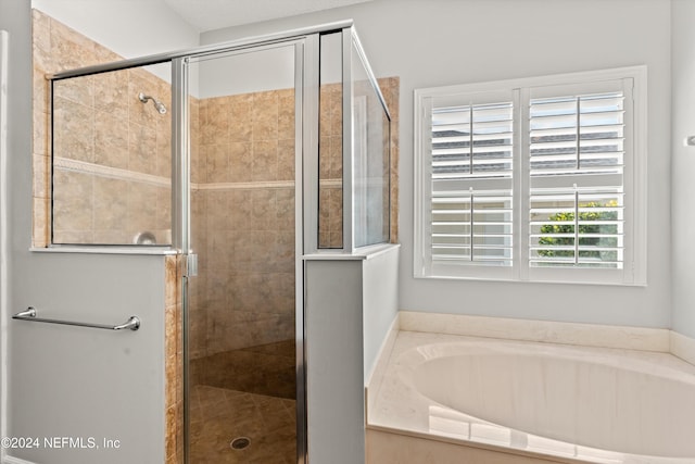 bathroom featuring shower with separate bathtub