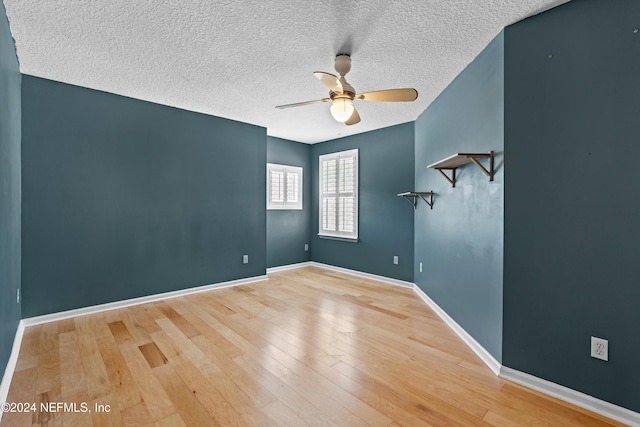 spare room with ceiling fan, wood-type flooring, and a textured ceiling