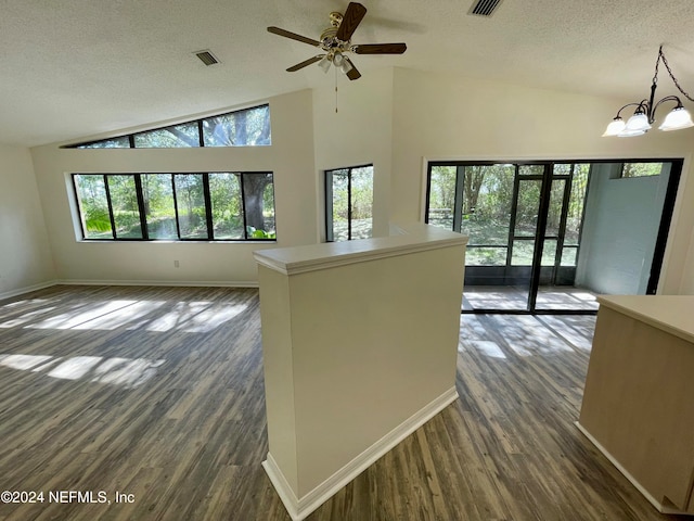 interior space with dark wood-type flooring, plenty of natural light, pendant lighting, and a textured ceiling