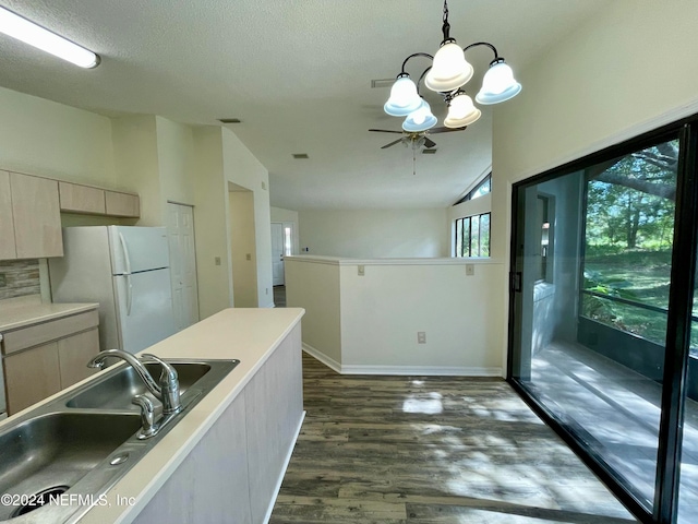 kitchen featuring dark hardwood / wood-style flooring, a textured ceiling, sink, pendant lighting, and lofted ceiling