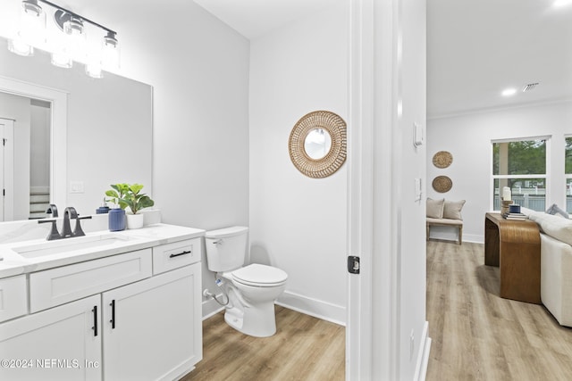 bathroom with vanity, toilet, and hardwood / wood-style floors