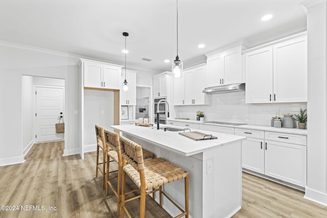 kitchen featuring white cabinetry, pendant lighting, and a center island with sink