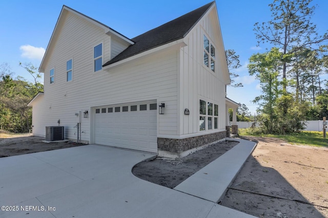 view of side of property featuring a garage and central air condition unit