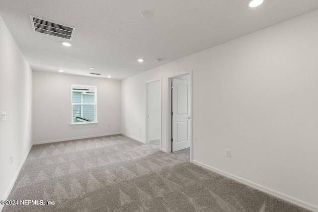 unfurnished room featuring light carpet