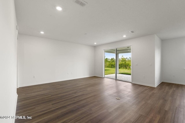 unfurnished room with a textured ceiling and dark wood-type flooring