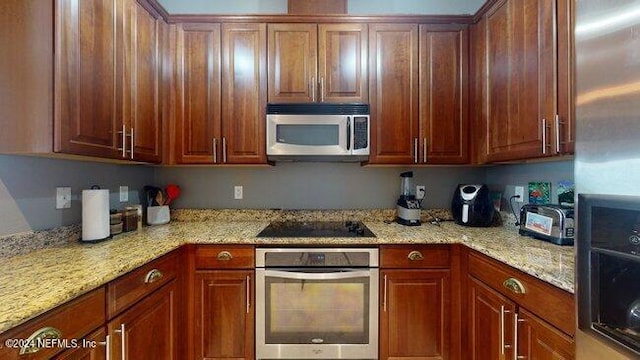 kitchen featuring light stone counters and stainless steel appliances