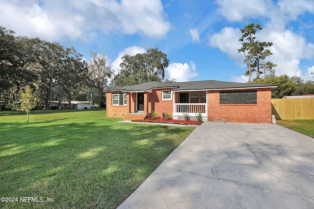 ranch-style house with a porch and a front lawn