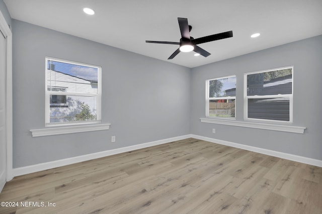 empty room with light hardwood / wood-style flooring, plenty of natural light, and ceiling fan