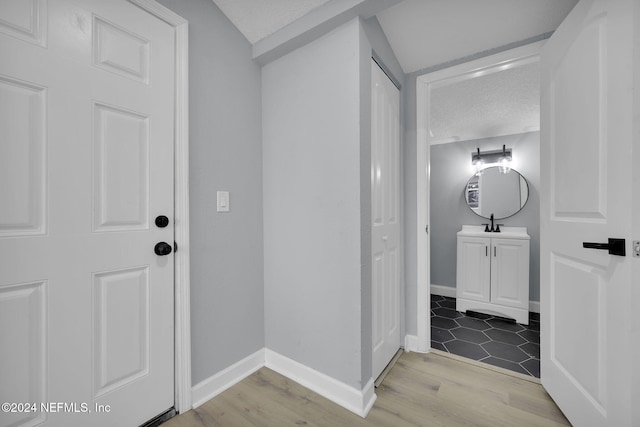 corridor featuring a textured ceiling and light hardwood / wood-style flooring