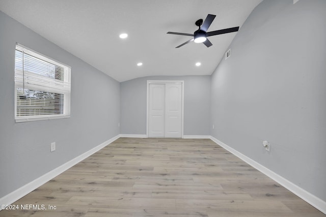 empty room with light wood-type flooring, ceiling fan, and lofted ceiling