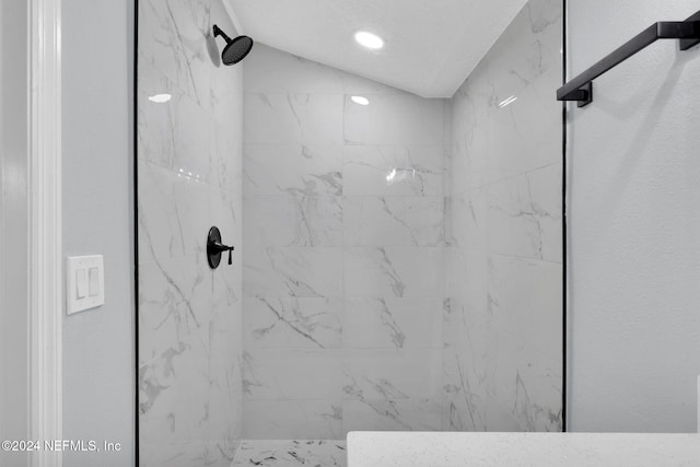 bathroom with tiled shower and vaulted ceiling